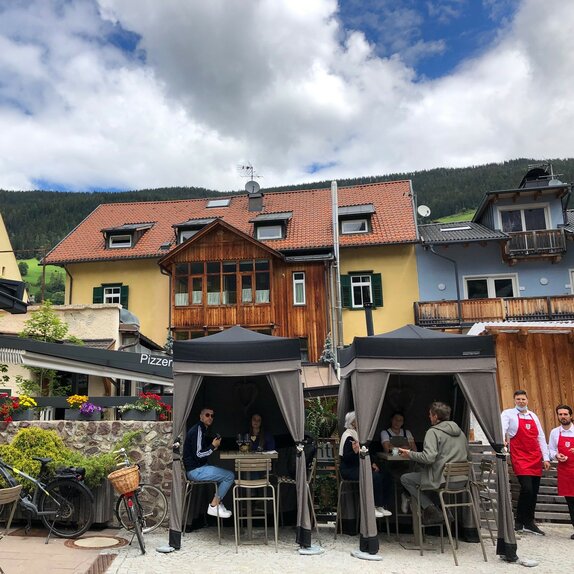 Due gazebo Loden di Mastertent sono situati sulla terrazza di un bistrò. Servono come tende per il catering. I clienti si godono le bevande sotto.  