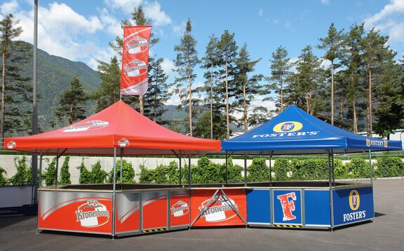 Chioschi personalizzati Una chiosco personalizzato della ditta Kronenbourg è collegato ad un stand personalizzato della ditta Fosters.