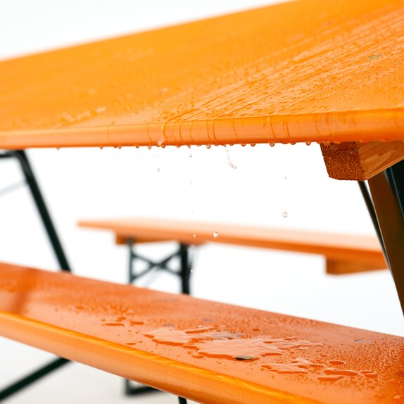 The beer bench is inclined. The water is dropping off from the table and falling onto the beer bench.
