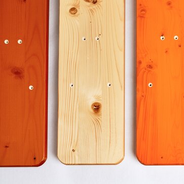 Tre pianali delle panche da birreria uno di fianco all´altro nei colori marrone, naturale e ocra.