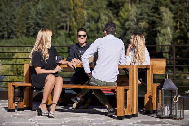Die besonderen Klappmöbel - "Lago"-Garnitur - steht auf der Terrasse. Es sitzen vier Personen am Tisch.