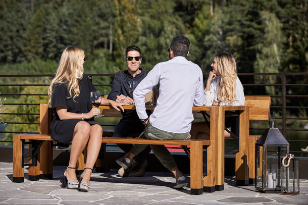 The special folding furniture "Lago" is placed at the terrace. There are four people sitting at the table.