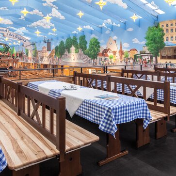 Custom-made sets for the Hacker Pschorr marqueee at the Oktoberfest. The tables have a blue and white checkered tablecoth. 