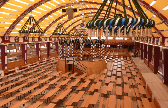 Biertischgarnituren mit Comfort-Untergestell stehen im Löwenbräu Festzelt auf dem Oktoberfest. Es sind noch keine Besucher im Zelt.