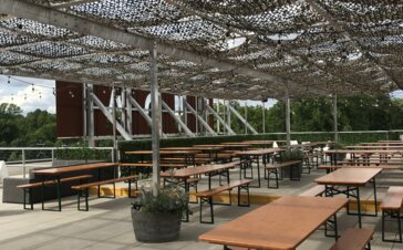 Die Brauerei-Sets befinden sich auf der Außenterrasse der Wooden Robot Brewery in den Vereinigten Staaten und sind durch ein Netz vor der Sonne geschützt.