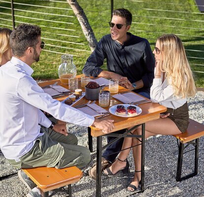 Two couples are sitting at the beer table set Shorty. They are heaving lunch at the terrace. 
