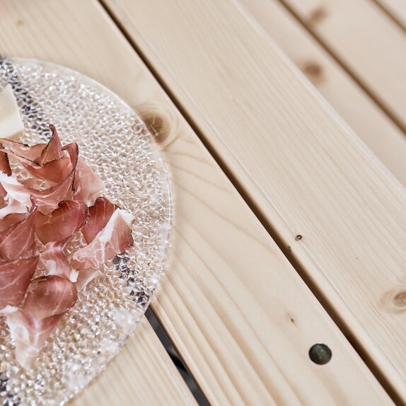 Detailed view of the "SitDown" beer table. The table consists of individual slats. A bacon plate can be seen in part.