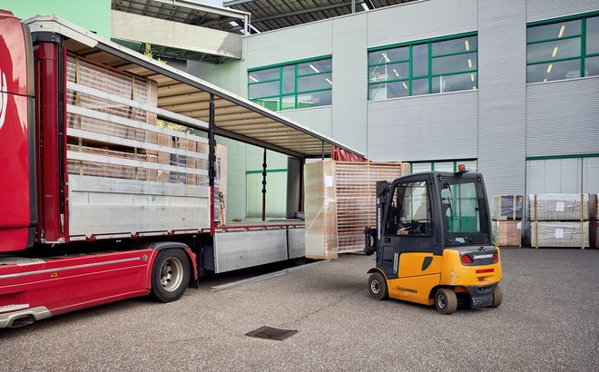 Die Bierzeltgarnituren werden im Transportcontainer mit dem Stapler auf den LKW verladen.