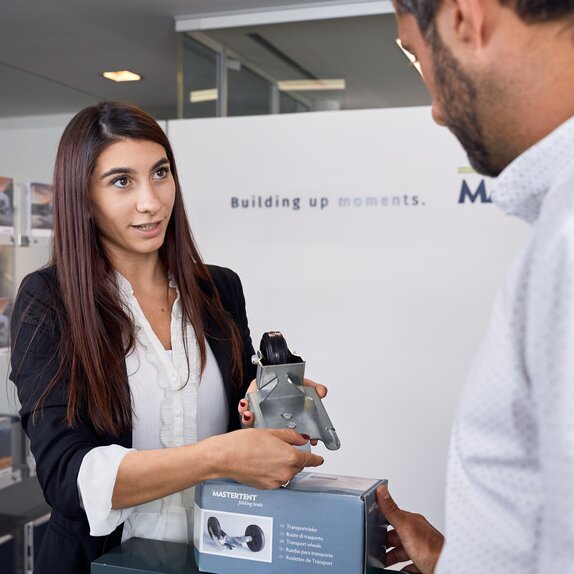 The employee shows the client the transport wheel.