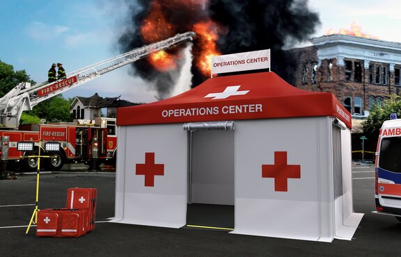 Gazebo pieghevole rescue rosso e bianco durante un'operazione dei vigili del fuoco. Un edificio sta bruciando sullo sfondo. I vigili del fuoco spengono l'incendio con l'aiuto della scala girevole.