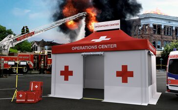 Gazebo pieghevole rescue rosso e bianco durante un'operazione dei vigili del fuoco. Un edificio sta bruciando sullo sfondo. I vigili del fuoco spengono l'incendio con l'aiuto della scala girevole.