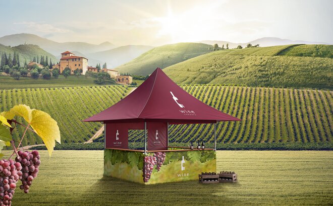 A red gazebo with four awnings is located in the middle of the vines. The sidewalls are printed with vines. In front of the gazebo two boxes with wine bottles are situated. 