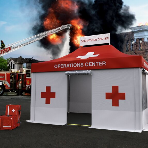 Red and white Rescue gazebo during a fire brigade gazebo. A building is burning in the background. The fire brigade is extinguishing the fire with the help of the turntable ladder. 