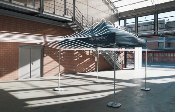 Il gazebo pieghevole con un tetto blu si trova nel canale al vento. Il vento è stato evidenziato con righe in bianco.