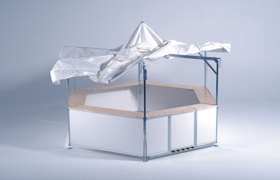 Il tetto sta per essere montato sulla struttura del chiosco esagonale.