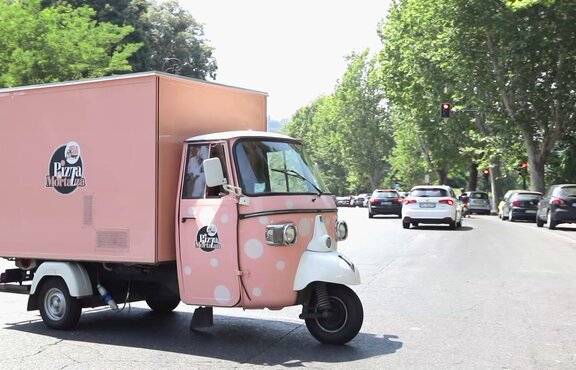 Il triciclo rosa di Pizza e Mortazza sulla strada. Il triciclo è completamente personalizzato.