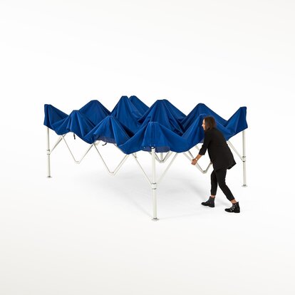 Frau zieht die Struktur des blauen Faltpavillons auseinander.