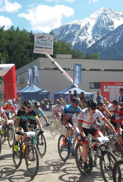Gazebo pieghevole professionale Mastertent 3x3 con pareti laterali e bandiera su tetto ad una gara sportiva di ciclismo