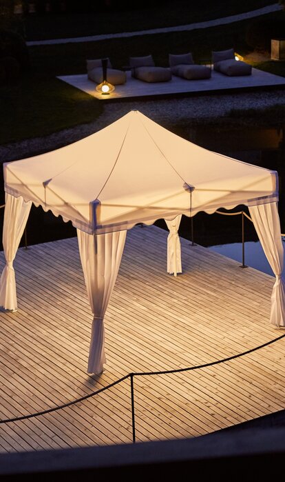 Gazebo pieghevole Mastertent con illuminazione su un molo di notte.