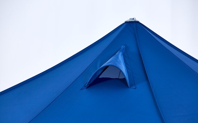 Il tetto di un gazebo blu ha un speciale abbaino sul tetto, che permette al fumo di fuoriuscire.