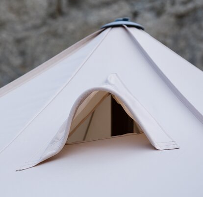 Ventilation system at the roof of a smoker's tent. It includes a net through which the smoke can exit easily. 