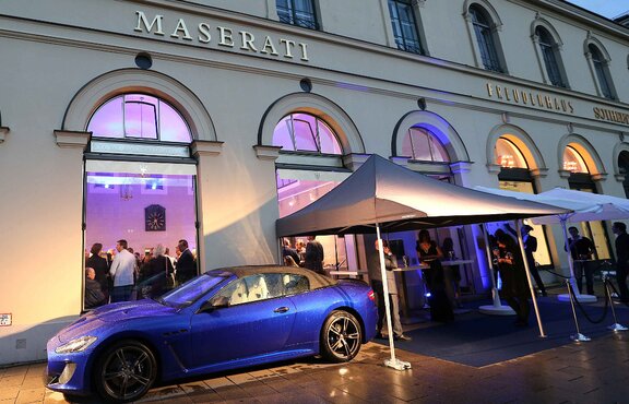 Schwarzer Faltpavillon mit Vordach bei einem Event von Maserati. Daneben steht ein blauer Maserati.