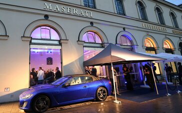 Schwarzer Faltpavillon mit Vordach bei einem Event von Maserati. Daneben steht ein blauer Maserati.