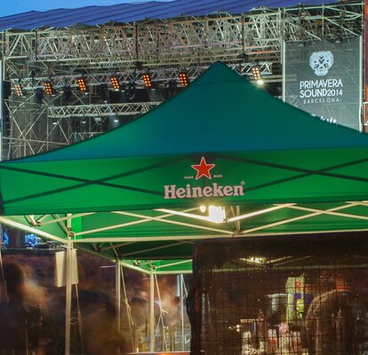 Grüner Faltpavillon von Heineken vor der Bühne. Er wird als Getränkestand bei einem Event genutzt.