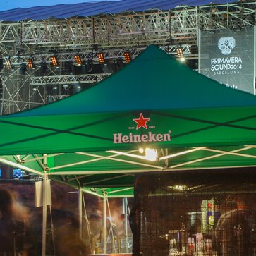 Grüner Faltpavillon von Heineken vor der Bühne. Er wird als Getränkestand bei einem Event genutzt.