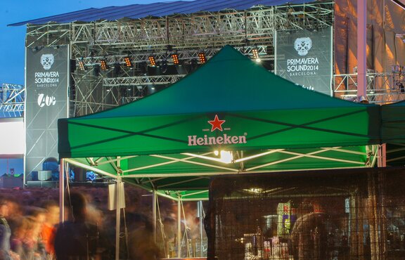 A green gazebo from Heineken is located in front of the stage. It is used as a beverage stand at the event. 