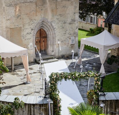 Gazebo nuziale color ecru davanti ad una chiesa. Il tappeto bianco porta alla chiesa.