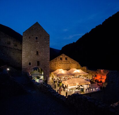 Gazebo nuziale di sera. Si trova davanti ad un castello, è illuminato.