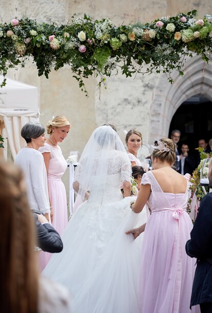 Eleganter Faltpavillon von Mastertent für eine Hochzeit. Man sieht die Braut von hinten zur Kirche kommen.