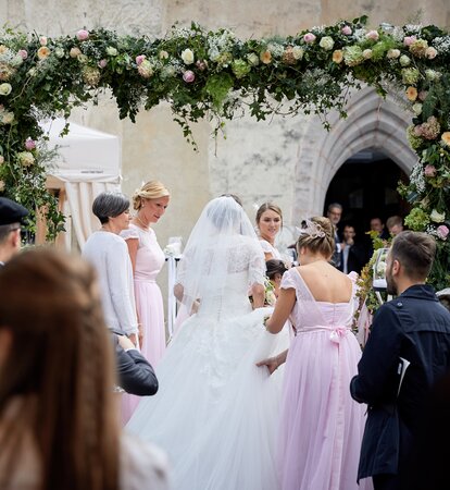 Eleganter Faltpavillon von Mastertent für eine Hochzeit. Man sieht die Braut von hinten zur Kirche kommen.