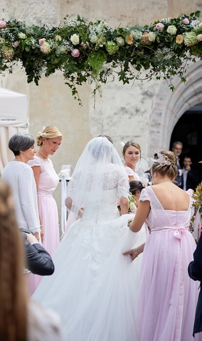 Eleganter Faltpavillon von Mastertent für eine Hochzeit. Man sieht die Braut von hinten zur Kirche kommen.