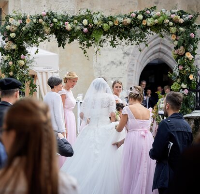 Eleganter Faltpavillon von Mastertent für eine Hochzeit. Man sieht die Braut von hinten zur Kirche kommen.