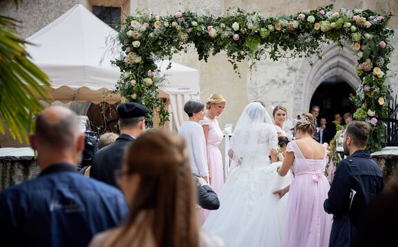 Eleganter Faltpavillon von Mastertent für eine Hochzeit. Man sieht die Braut von hinten zur Kirche kommen.