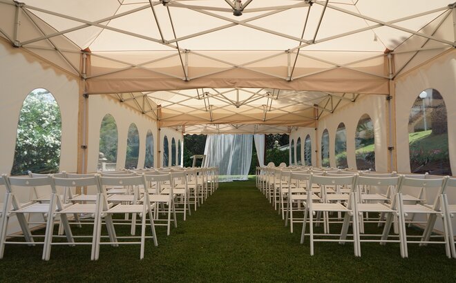 Das Pagodenzelt in ecru im Einsatz als Hochzeitszelt. Der Faltpavillon ist mit Stühlen ausgestattet und feierlich vorbereitet.
