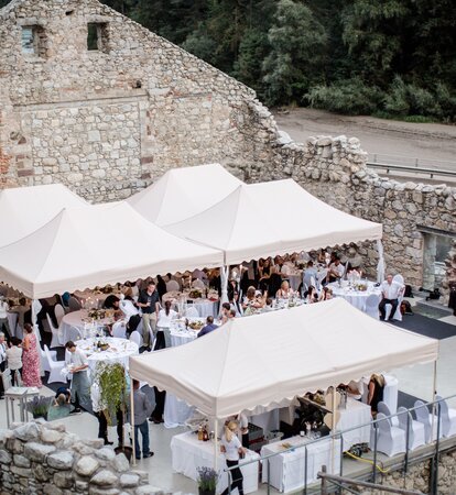 Verschiedene Faltpavillons in eleganter Ausführung bei einer Hochzeit. Damit werden die Gäste überdacht, die darunter sitzen.