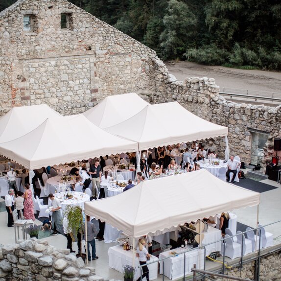 Verschiedene Faltpavillons in eleganter Ausführung bei einer Hochzeit. Damit werden die Gäste überdacht, die darunter sitzen.