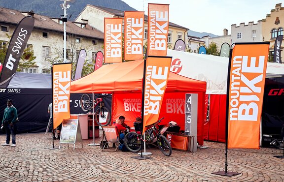 Orange promotion tent for mountainbikers with flags by MASTERTENT 