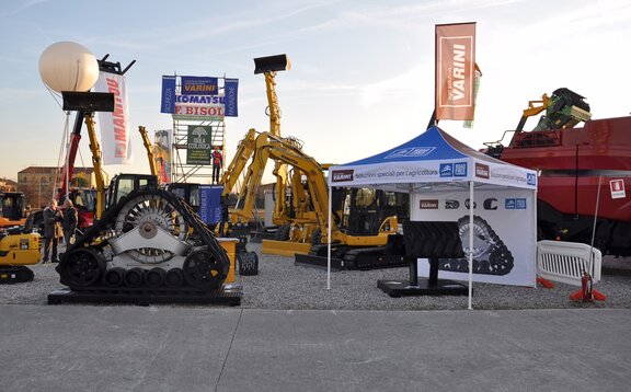 Gazebo pieghevole di Varini su una fiera outdoor. Il gazebo è personalizzato. Vicino si trova una ruspa e qualche macchinario