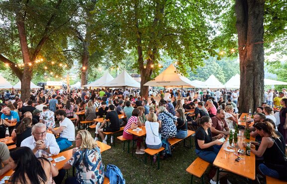 Faltpavillons beim Street Food Festival in Brixen. Besucher schlendern zwischen den Ständen, genießen Speisen und Getränke.
