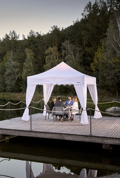 An elegant canopy tent set up for outdoor dining.