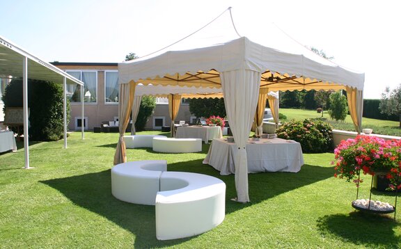 Gazebo pieghevole elegante in giardino Una gazebo pieghevole elegante con copripali ad una festa all´aperto. Sotto il gazebo pieghevole c' è un set da birreria.