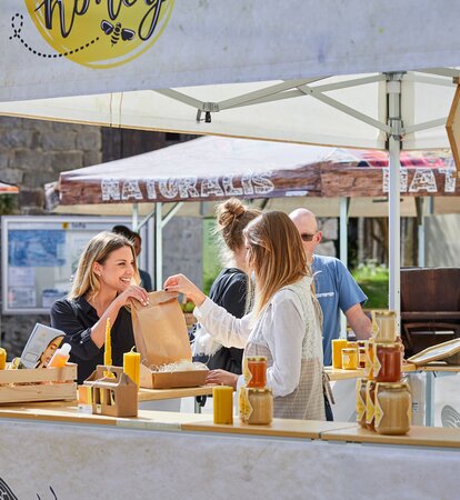 3x3 m große quadratische Marktzelt mit Flachdach und halbhohen Wänden mit Theke für den Honigverkauf. Vollständig individuell gestalteter Pavillon mit Fotos und Logo im Sublimationsdruck zum Thema Honig und Bienen. 