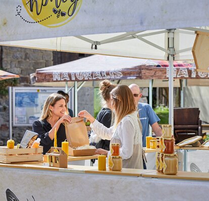 3x3 m große quadratische Marktzelt mit Flachdach und halbhohen Wänden mit Theke für den Honigverkauf. Vollständig individuell gestalteter Pavillon mit Fotos und Logo im Sublimationsdruck zum Thema Honig und Bienen. 