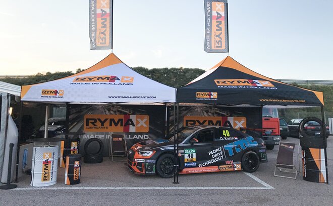 Fully personalised racing tent at a road event. It is fully printed. Underneath is a car. The racing team belongs to Rymax.