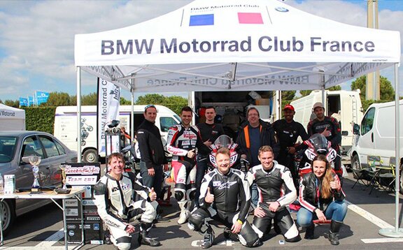 BMW Motorrad Club France Gazebo pieghevole per gare con la scritta "BMW Motorrad Club France". Sotto ci sono i membri della squadra.