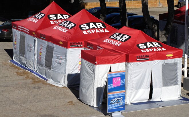 The four rescue tents of different sizes are connected to each other. They have white side walls and red tent roofs.